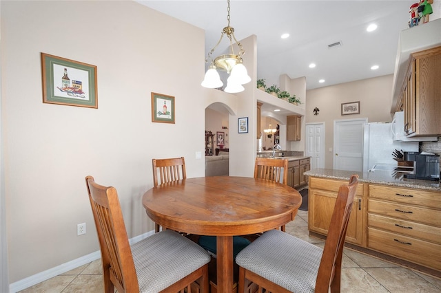 dining room with an inviting chandelier, light tile patterned floors, and sink