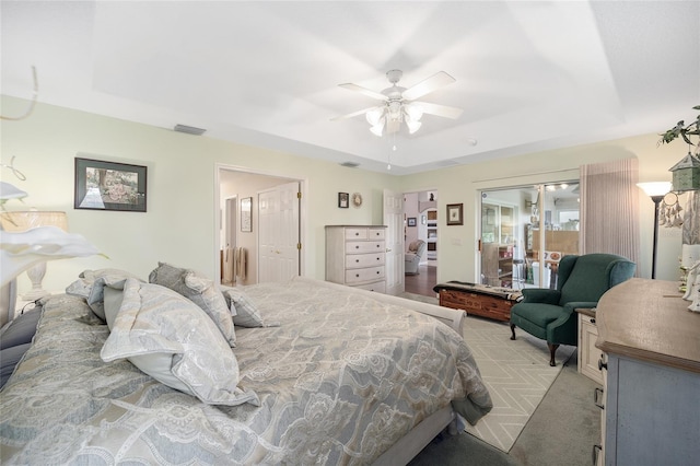 bedroom with a tray ceiling, ceiling fan, and light colored carpet