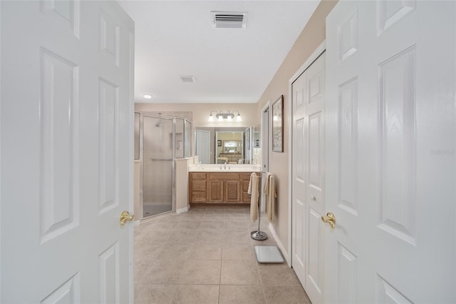 bathroom featuring tile patterned flooring, vanity, and walk in shower