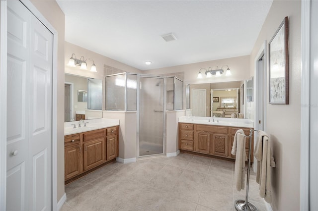 bathroom with tile patterned flooring, vanity, and a shower with shower door