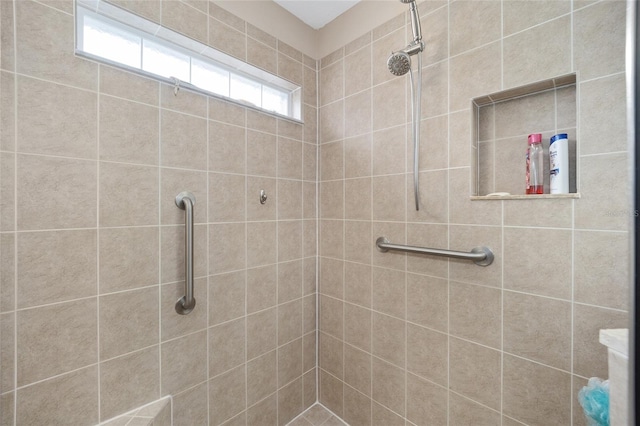 bathroom with a tile shower and plenty of natural light