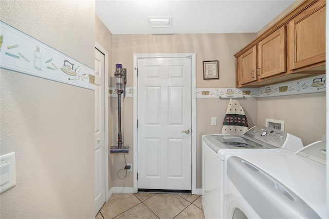 washroom featuring cabinets, separate washer and dryer, and light tile patterned floors