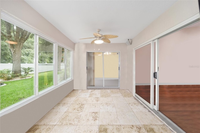 unfurnished sunroom with a healthy amount of sunlight and ceiling fan