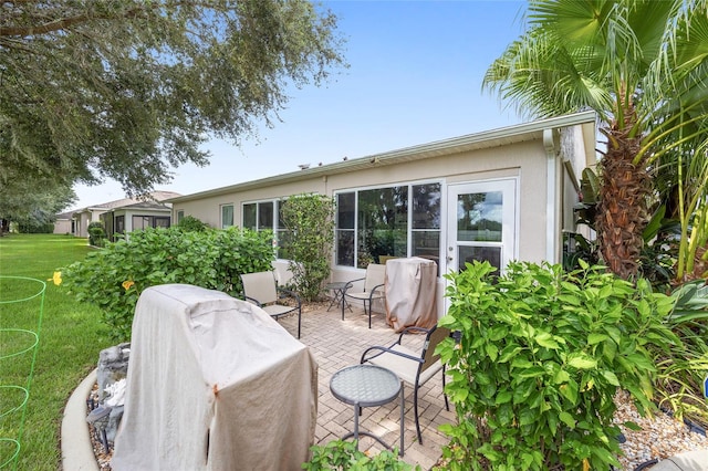 rear view of house featuring a yard and a patio area