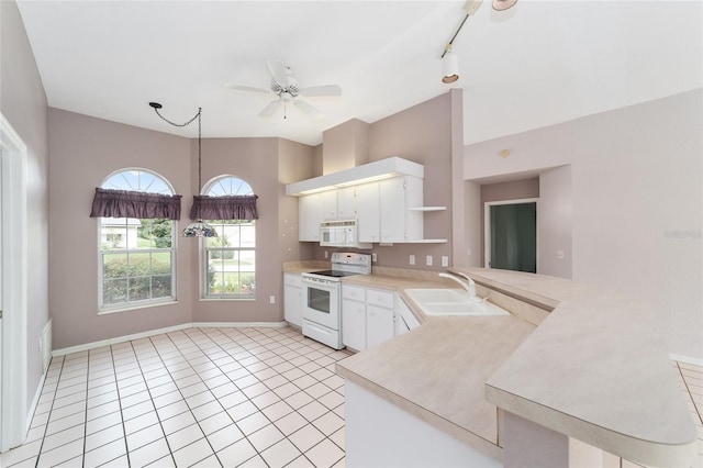 kitchen with white appliances, kitchen peninsula, sink, white cabinetry, and ceiling fan