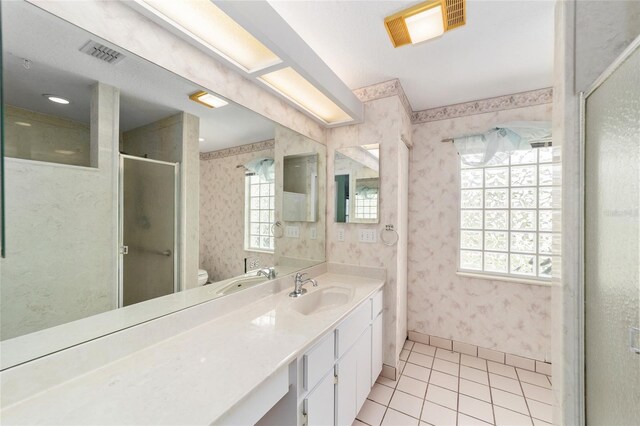 bathroom with tile patterned flooring, vanity, toilet, and a shower with shower door