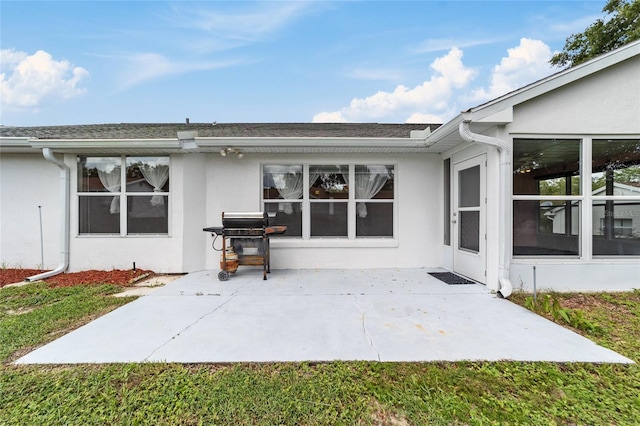 rear view of property with a sunroom and a patio area