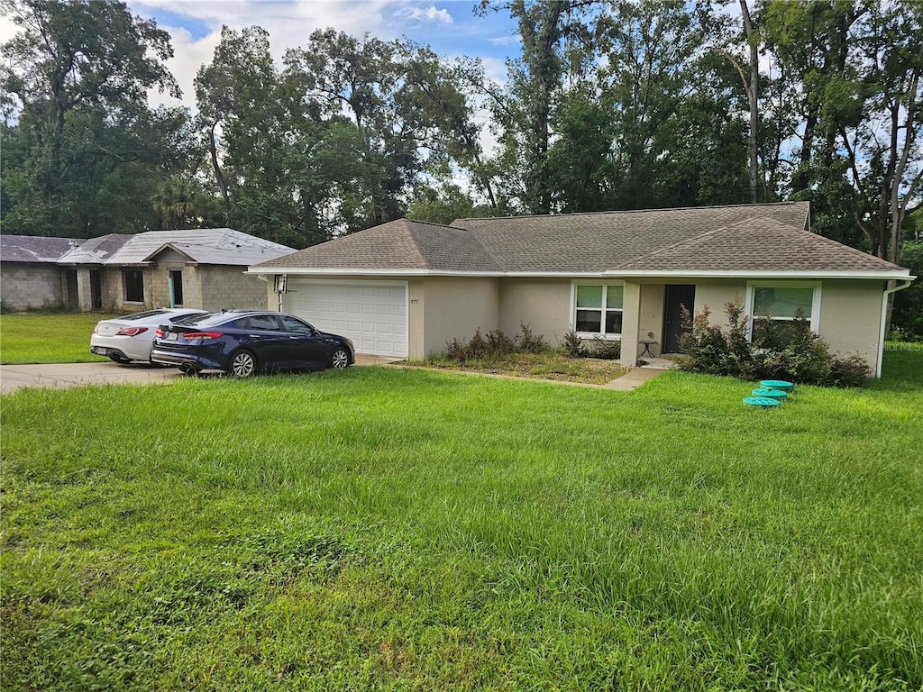 ranch-style house with a garage and a front lawn