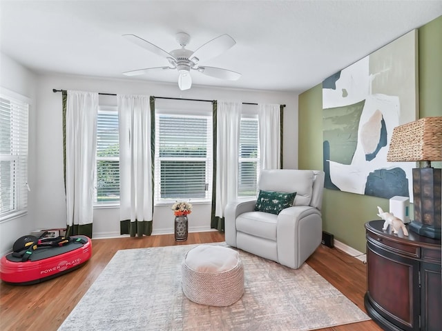 living area with light hardwood / wood-style flooring, ceiling fan, and plenty of natural light