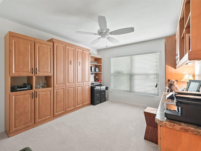 carpeted office featuring ceiling fan and a textured ceiling