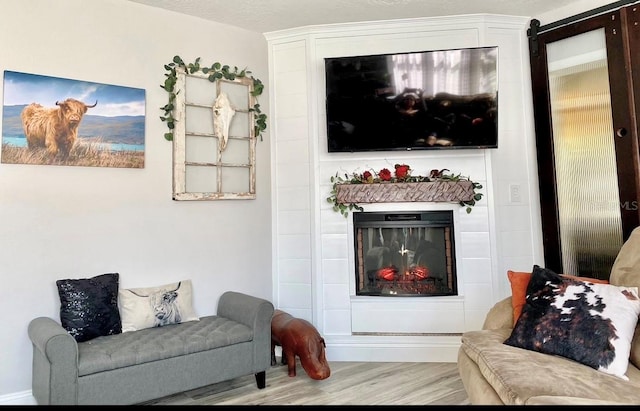 living room featuring light hardwood / wood-style flooring and a textured ceiling