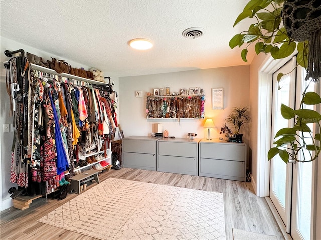 spacious closet with light hardwood / wood-style floors