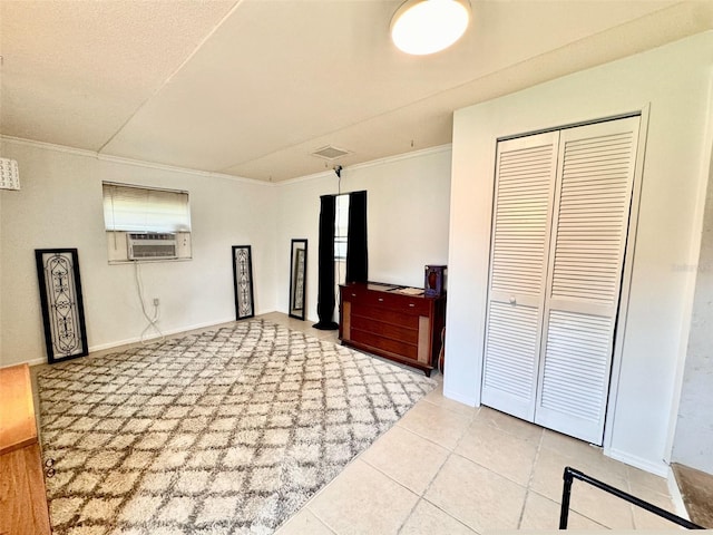 interior space with ornamental molding, a closet, and tile patterned flooring