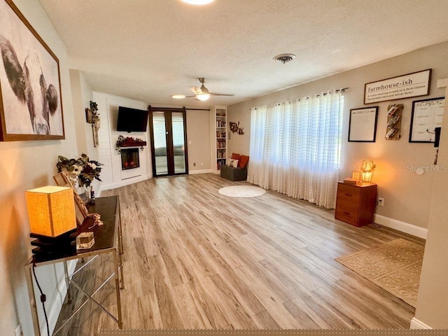 living area featuring a textured ceiling, ceiling fan, and hardwood / wood-style flooring