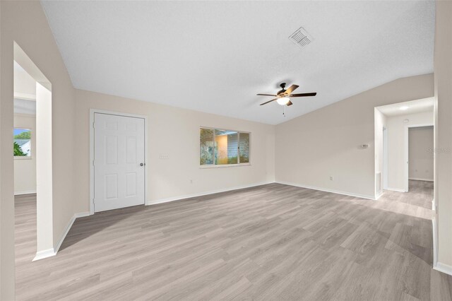 unfurnished living room featuring lofted ceiling, ceiling fan, a textured ceiling, and light hardwood / wood-style flooring