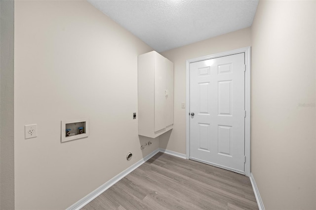 washroom featuring a textured ceiling, hookup for a washing machine, cabinets, light hardwood / wood-style floors, and electric dryer hookup