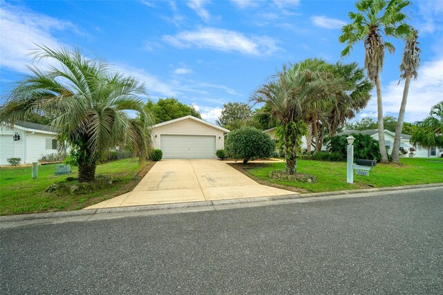 view of front of house with a garage, a front lawn, and an outbuilding