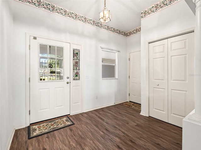 entrance foyer with ornate columns and dark wood-type flooring