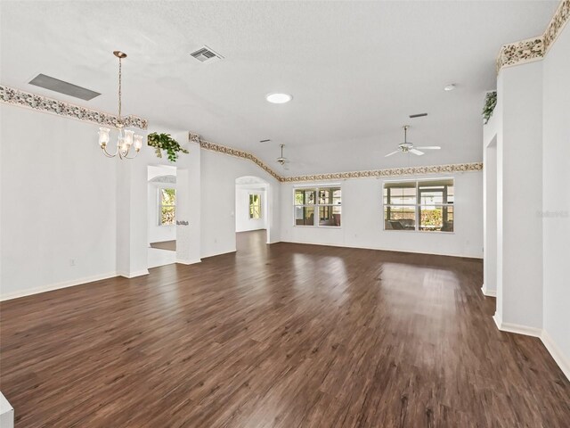 unfurnished living room with ceiling fan with notable chandelier, a textured ceiling, and dark hardwood / wood-style flooring