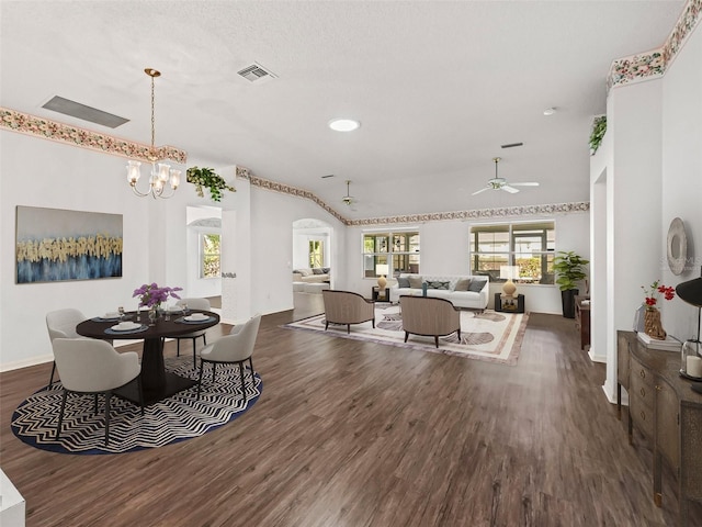 dining space featuring ceiling fan with notable chandelier and dark hardwood / wood-style flooring