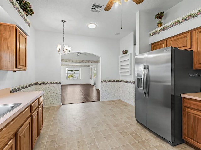 kitchen with stainless steel refrigerator with ice dispenser, ceiling fan with notable chandelier, light tile patterned floors, and hanging light fixtures