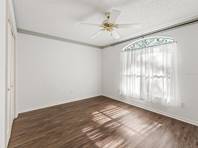 empty room with crown molding, ceiling fan, dark hardwood / wood-style flooring, and a textured ceiling