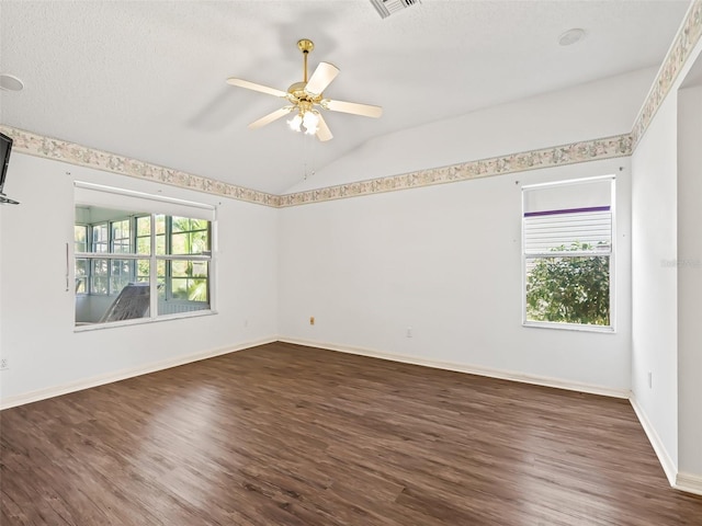 empty room featuring dark wood-type flooring, plenty of natural light, lofted ceiling, and ceiling fan