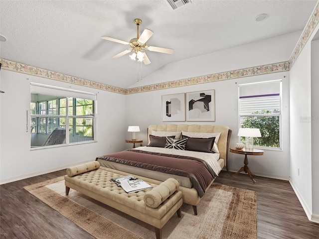 bedroom featuring multiple windows, dark hardwood / wood-style floors, ceiling fan, and lofted ceiling