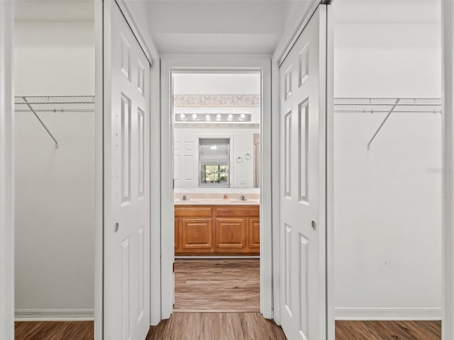 corridor featuring sink and wood-type flooring