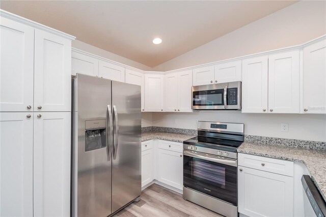 kitchen with light stone countertops, stainless steel appliances, and white cabinetry