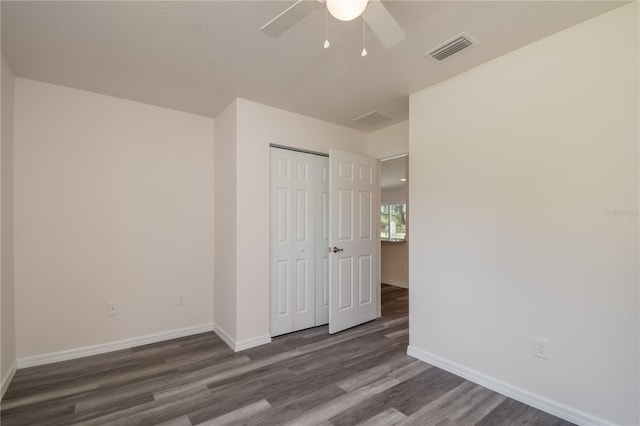 unfurnished bedroom with ceiling fan, a closet, and dark hardwood / wood-style floors