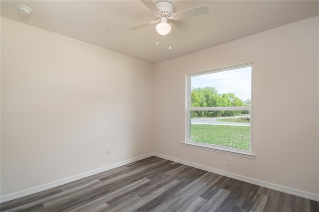 spare room featuring ceiling fan, plenty of natural light, and dark wood-type flooring