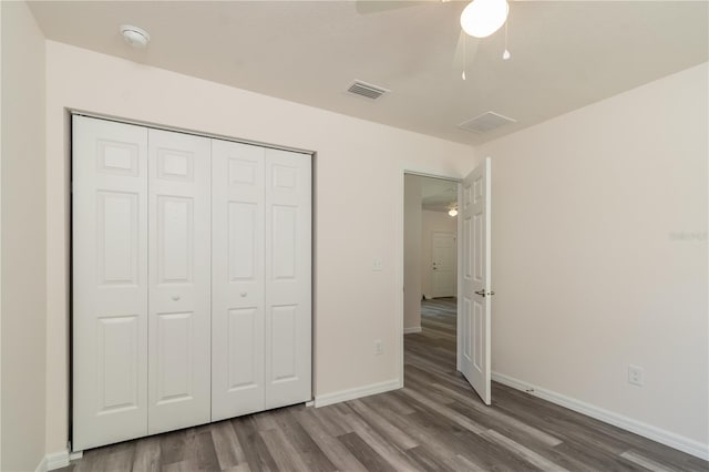 unfurnished bedroom featuring ceiling fan, a closet, and wood-type flooring