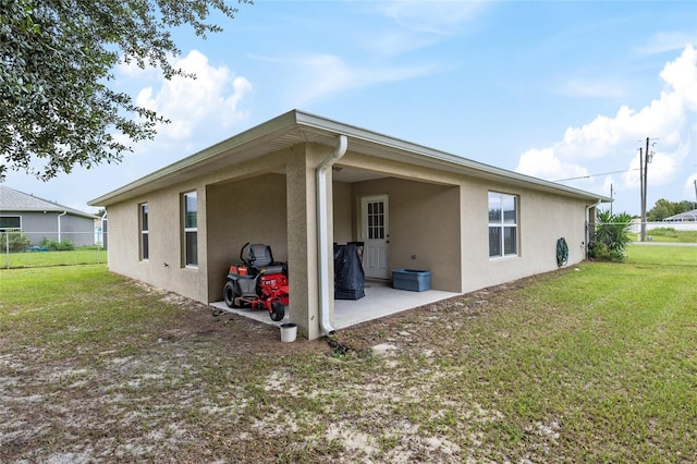 back of house with a patio and a yard