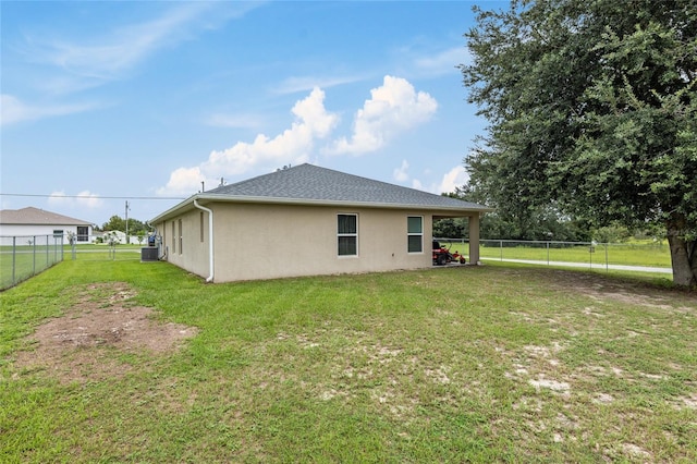 back of property featuring central AC unit and a yard