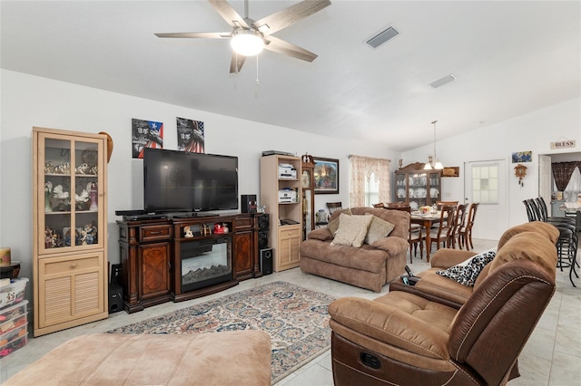 tiled living room with lofted ceiling and ceiling fan with notable chandelier