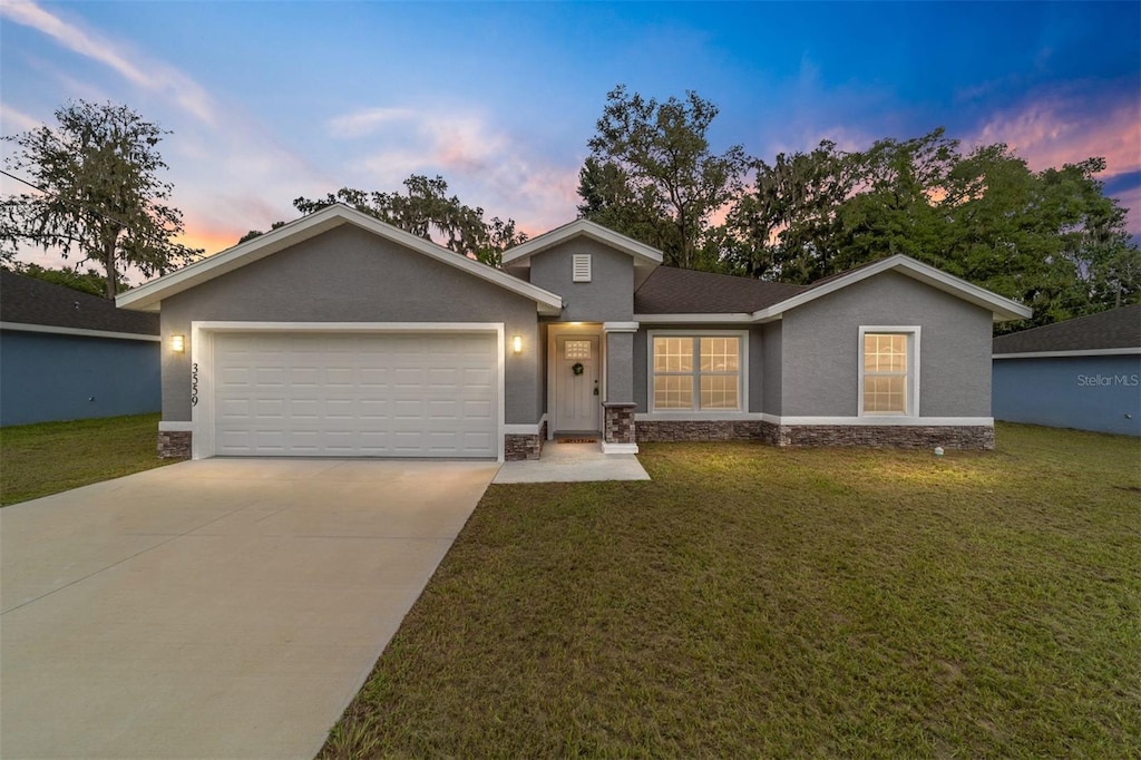 view of front of home featuring a garage and a lawn