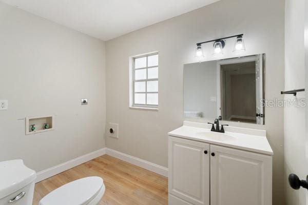 bathroom with wood-type flooring, vanity, and toilet