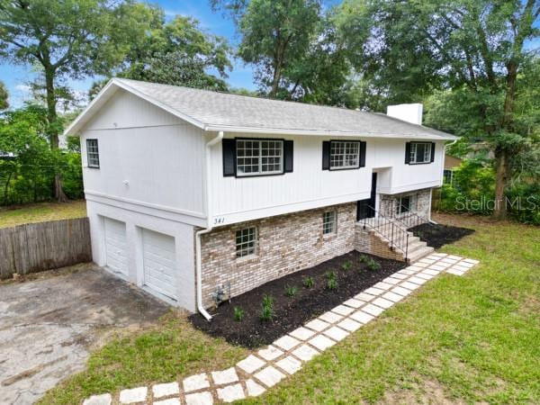 split foyer home featuring a front lawn and a garage