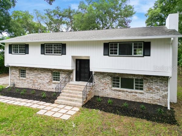 bi-level home with a front lawn