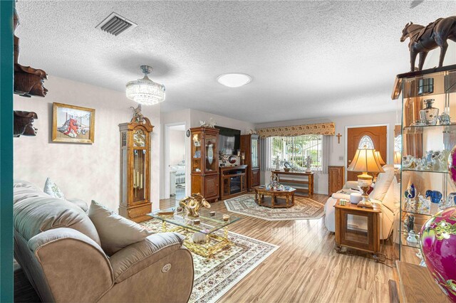 living room featuring a textured ceiling and light hardwood / wood-style floors