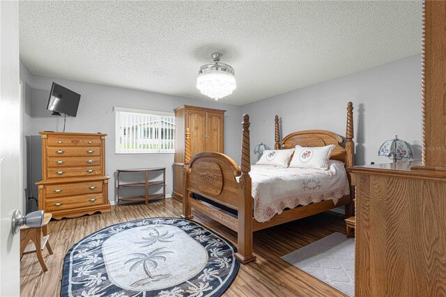 bedroom with a textured ceiling and light wood-type flooring