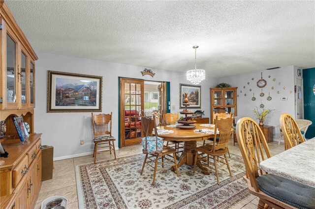 dining room with a textured ceiling and a chandelier