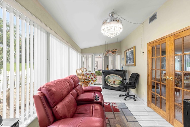 interior space featuring light wood-type flooring, french doors, lofted ceiling, and a chandelier