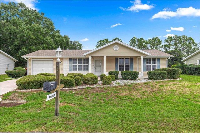 ranch-style house featuring a front lawn and a garage