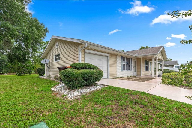 ranch-style home featuring a garage and a front lawn