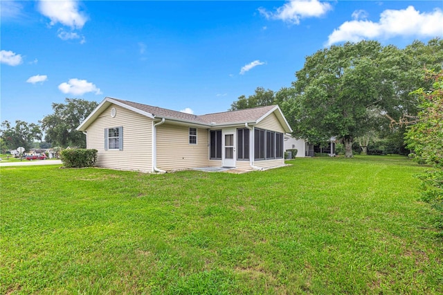 back of property featuring a lawn and a sunroom