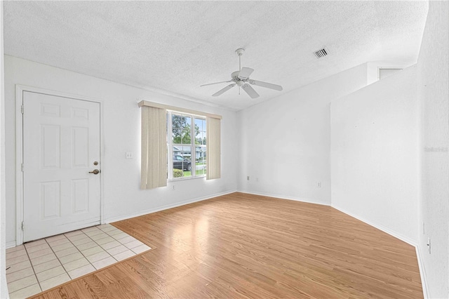 interior space with ceiling fan, a textured ceiling, and light hardwood / wood-style flooring