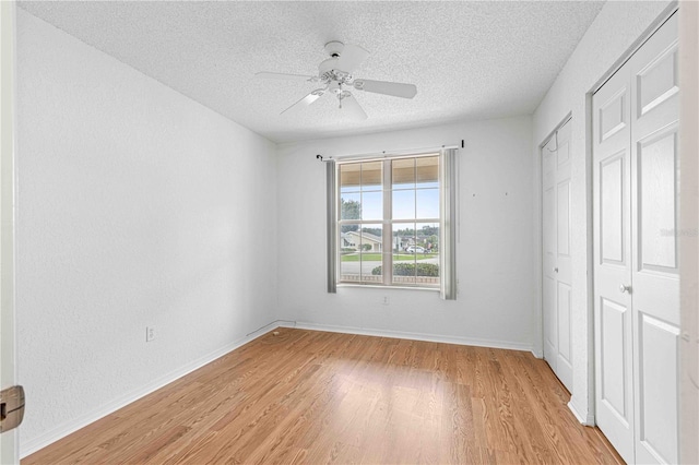 unfurnished bedroom featuring light wood-type flooring, a textured ceiling, and ceiling fan