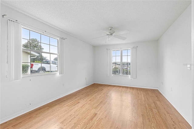 empty room featuring light wood-type flooring, ceiling fan, and a textured ceiling